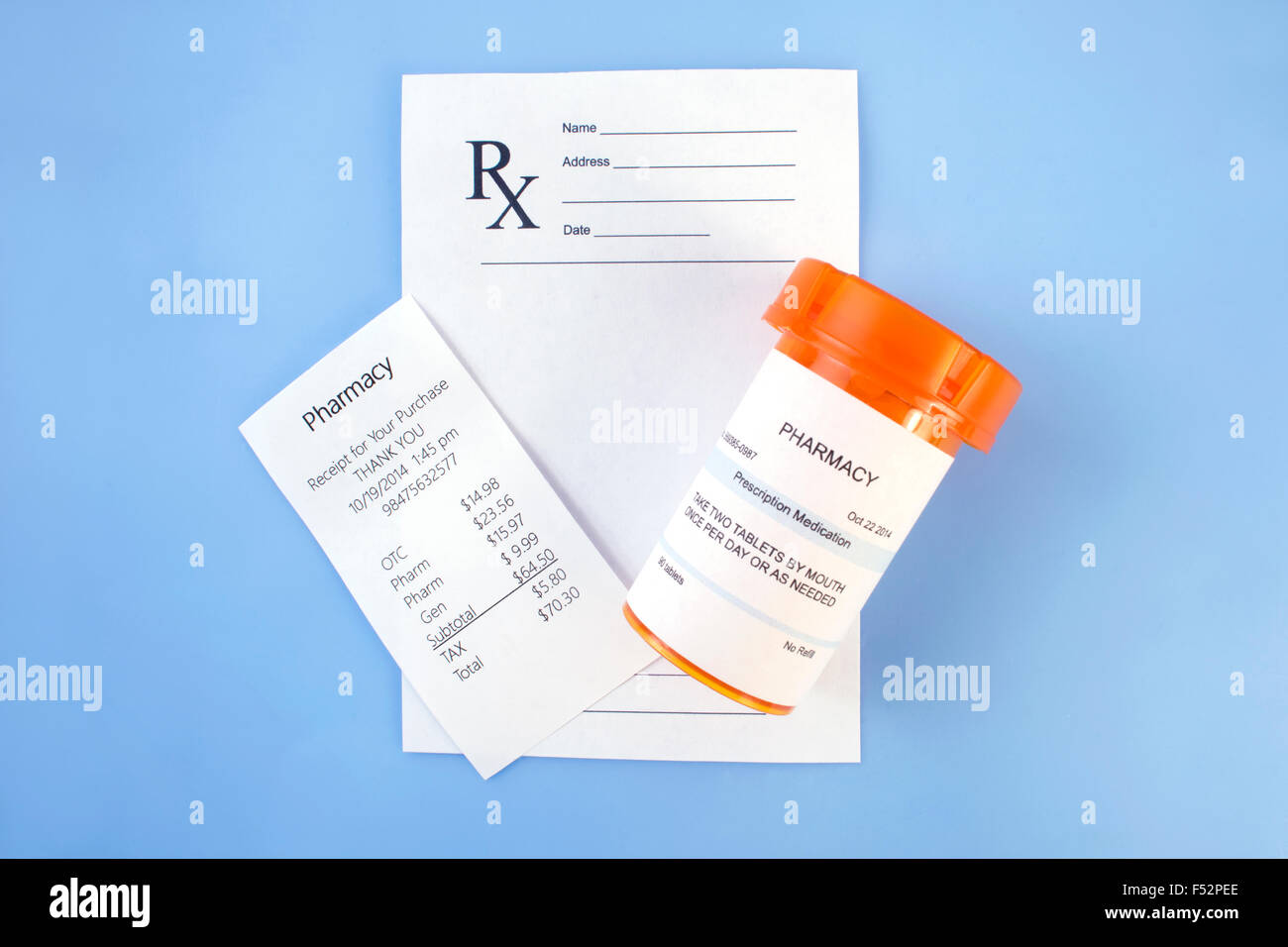 Pharmacy receipt with prescription bottle and receipt on blue. Stock Photo