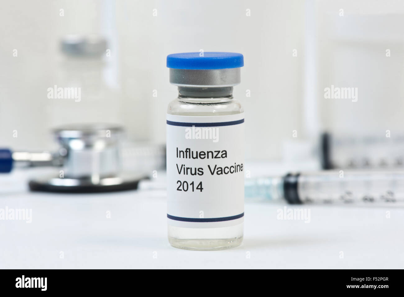 2014 influenza vaccine vial with office supplies in background. Stock Photo