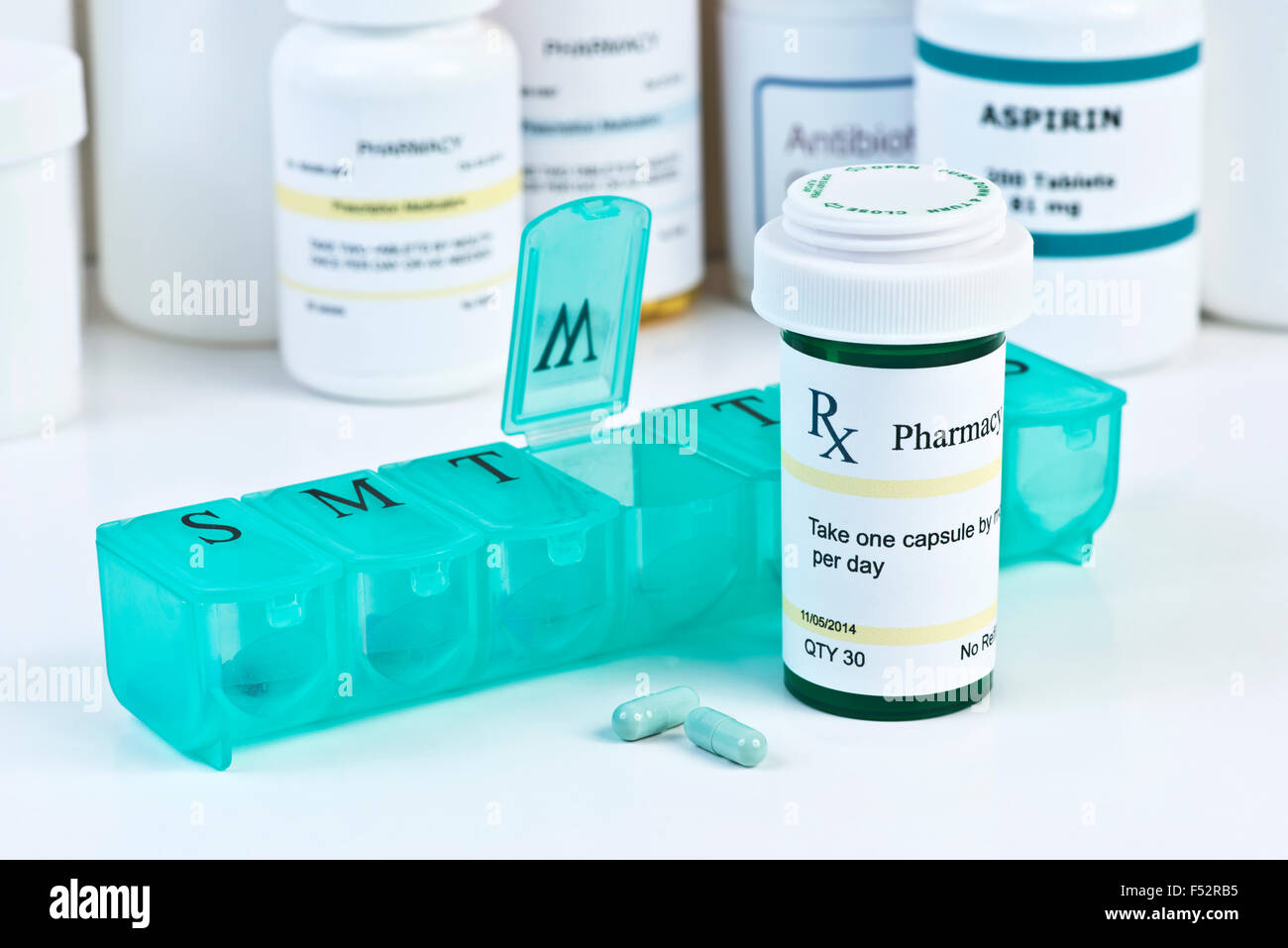 Daily medication dispenser with green prescription bottle and pills