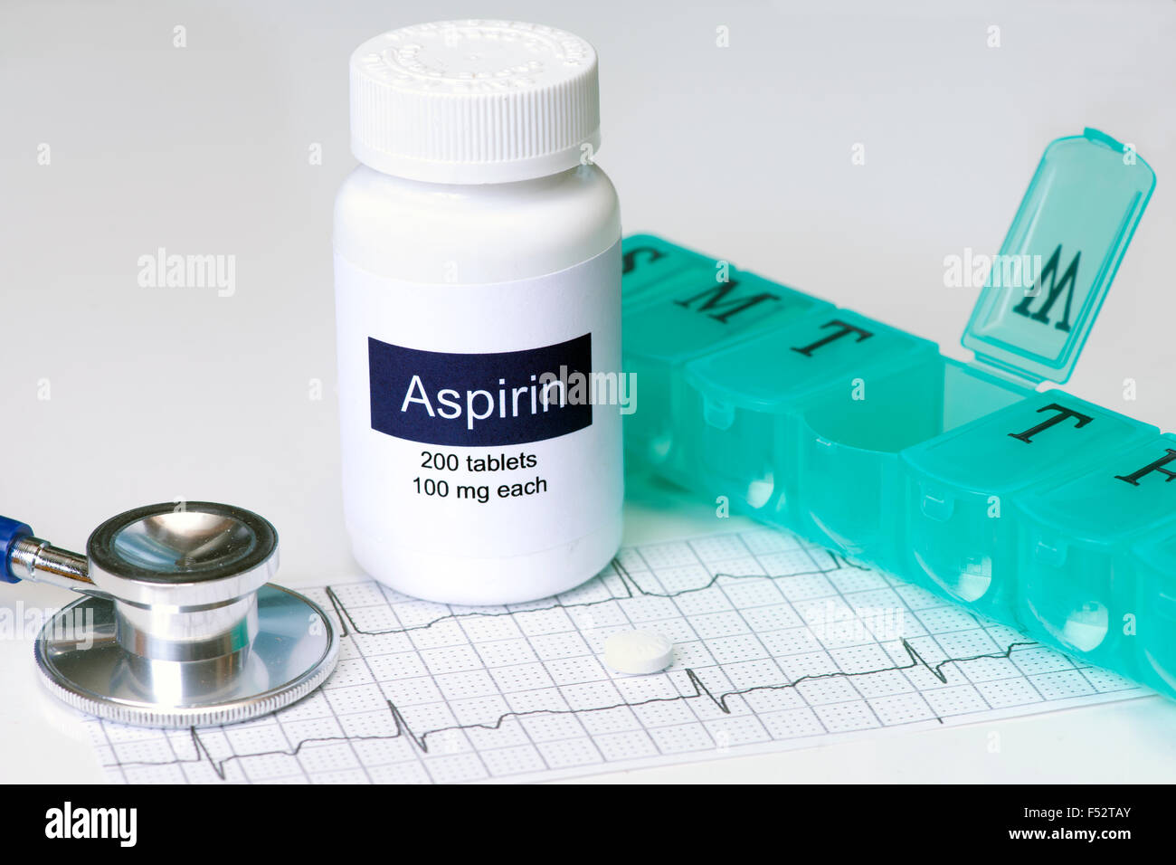 Daily aspirin dose with stethoscope and pill dispenser. Label is fictitious, created by photographer. Stock Photo