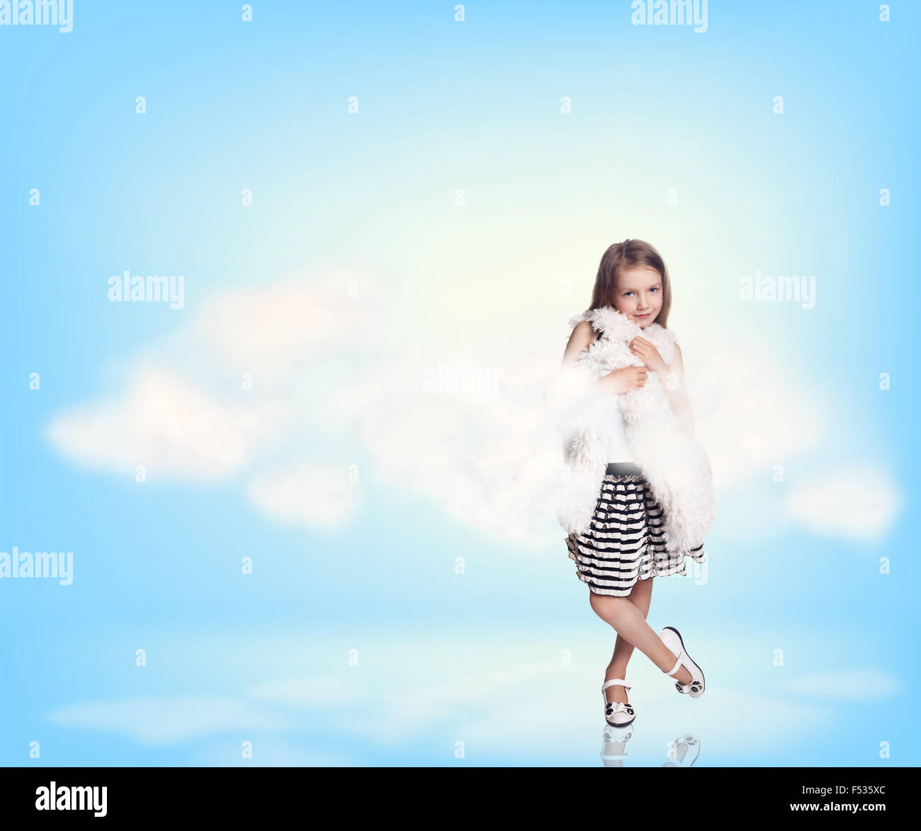 Cute little girl in blue sky with clouds Stock Photo - Alamy
