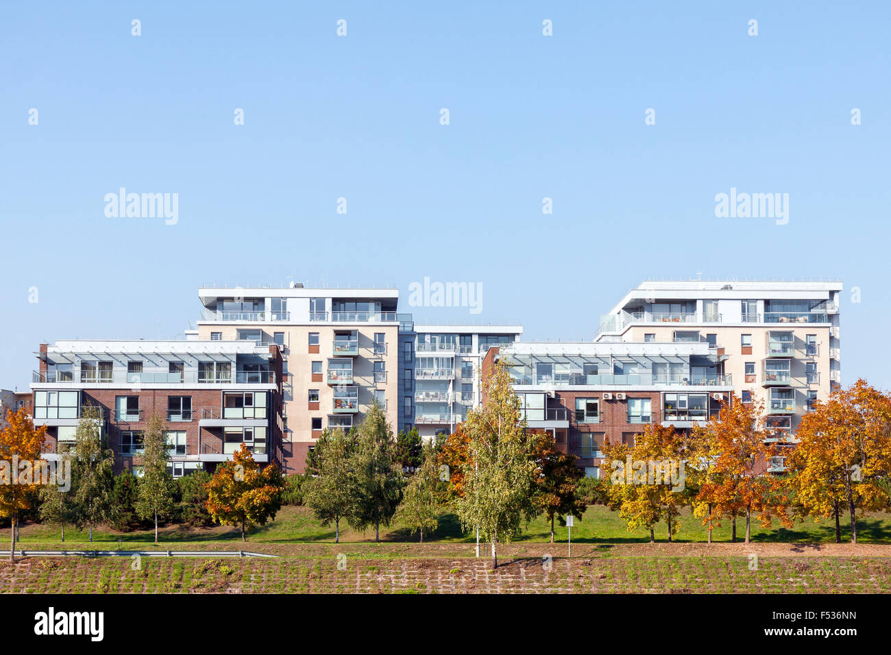 Modern residential apartment houses surrounded by yellow trees at autumn Stock Photo