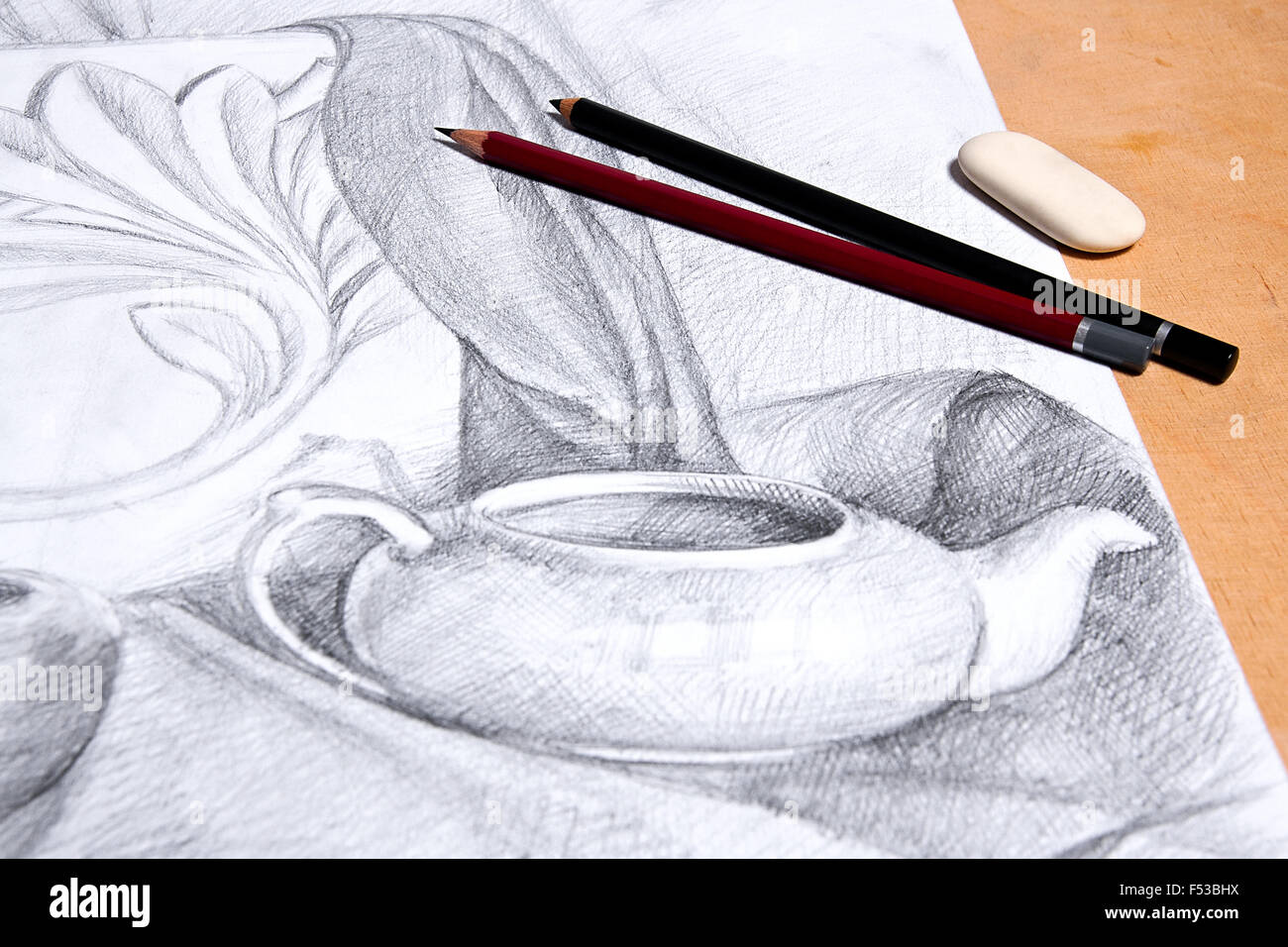 Drawing of still life by graphite pencil with apple, tea infuser and plaster palm leaf. Graphite pencils and eraser on the woode Stock Photo