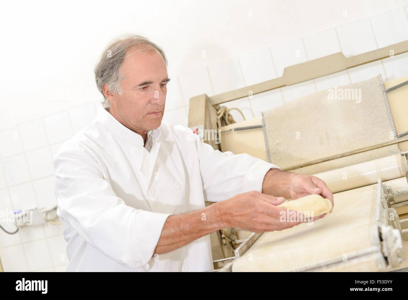 Baker placing dough onto conveyor Stock Photo Alamy