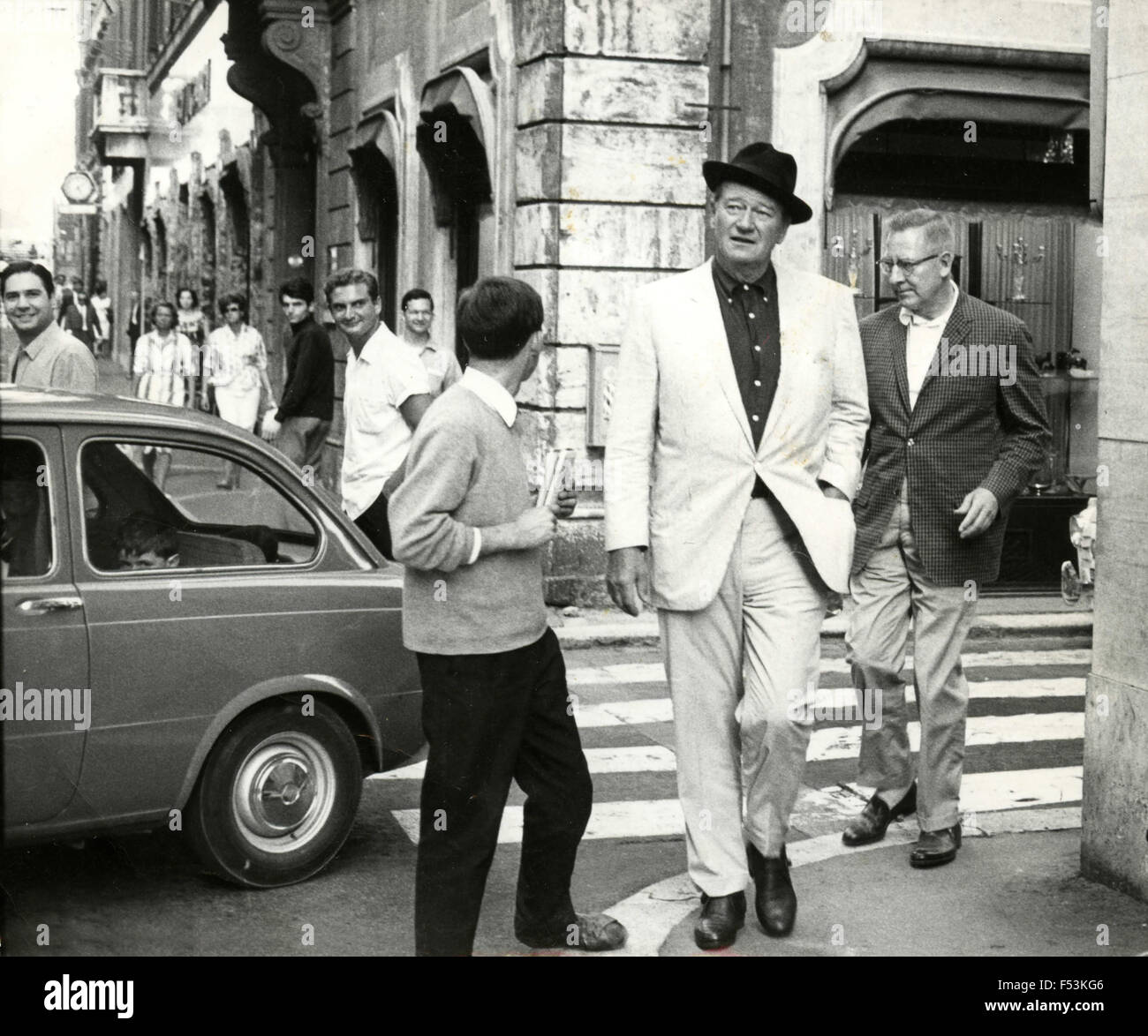 The American actor John Wayne strolling through the streets of Rome ...