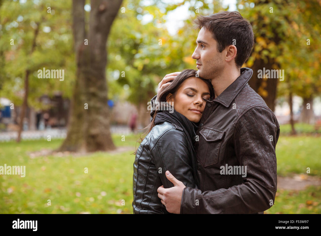 Portrait of a beautiful couple hugging outdoors in park Stock Photo - Alamy