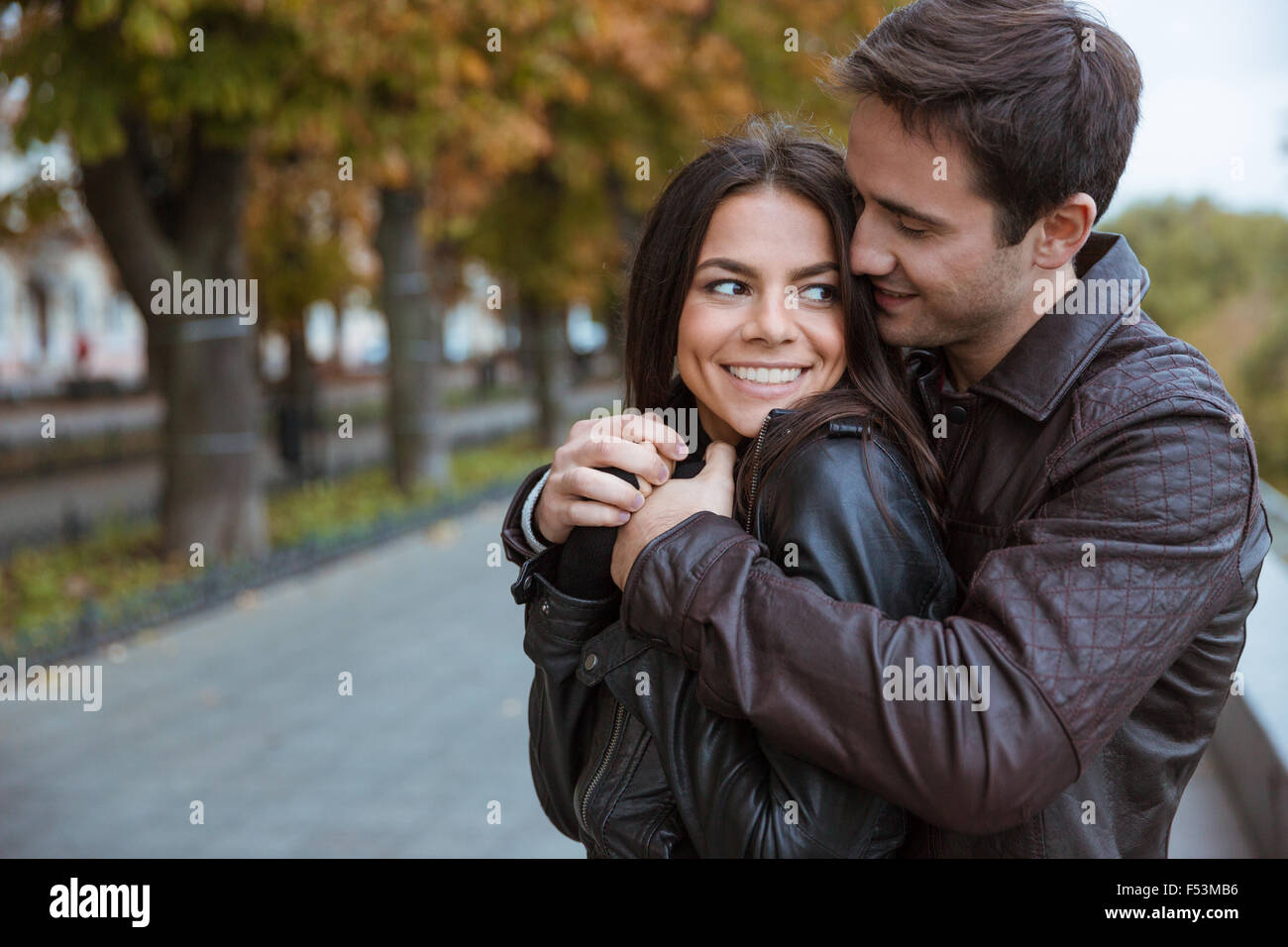 Portrait of a happy young couple flirting in autumn park Stock Photo ...