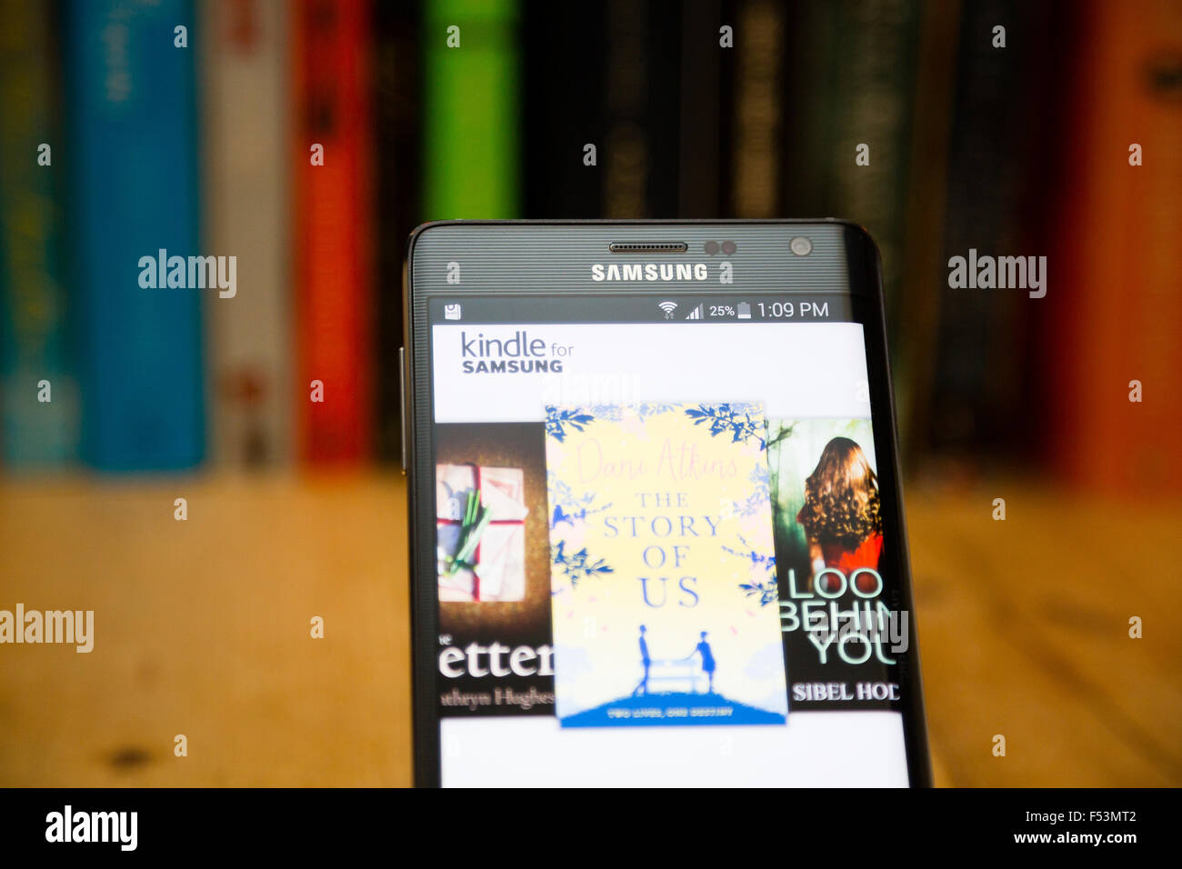 LONDON, UK. View of the Kindle store on a Samsung smartphone against a traditional bookshelf. Stock Photo