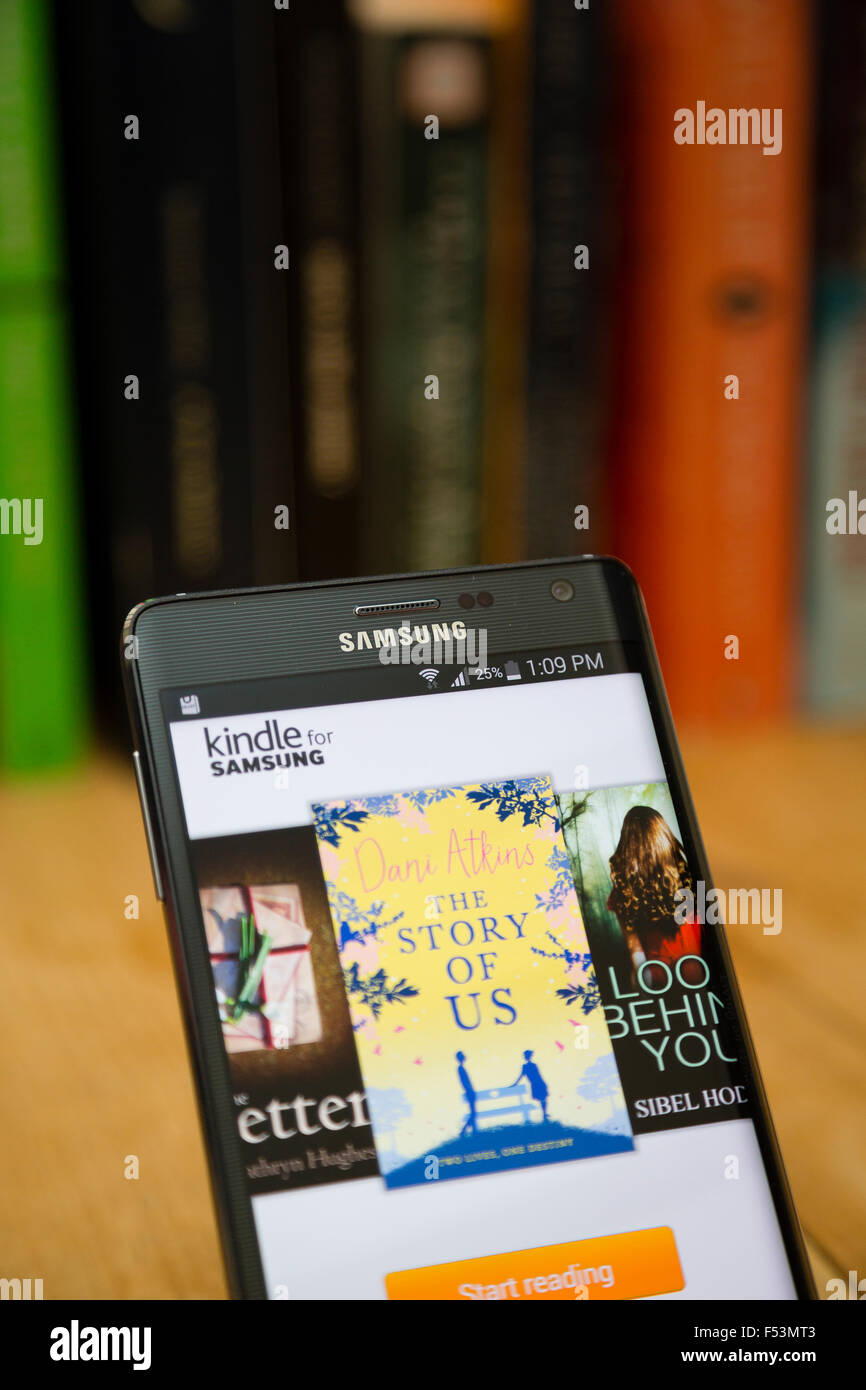 LONDON, UK. View of the Kindle store on a Samsung smartphone against a traditional bookshelf. Stock Photo