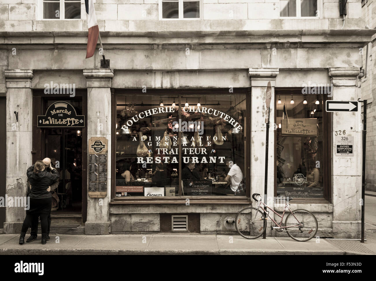 Couple kissing in front of restaurant in Old Montreal, Quebec, Canada Stock Photo