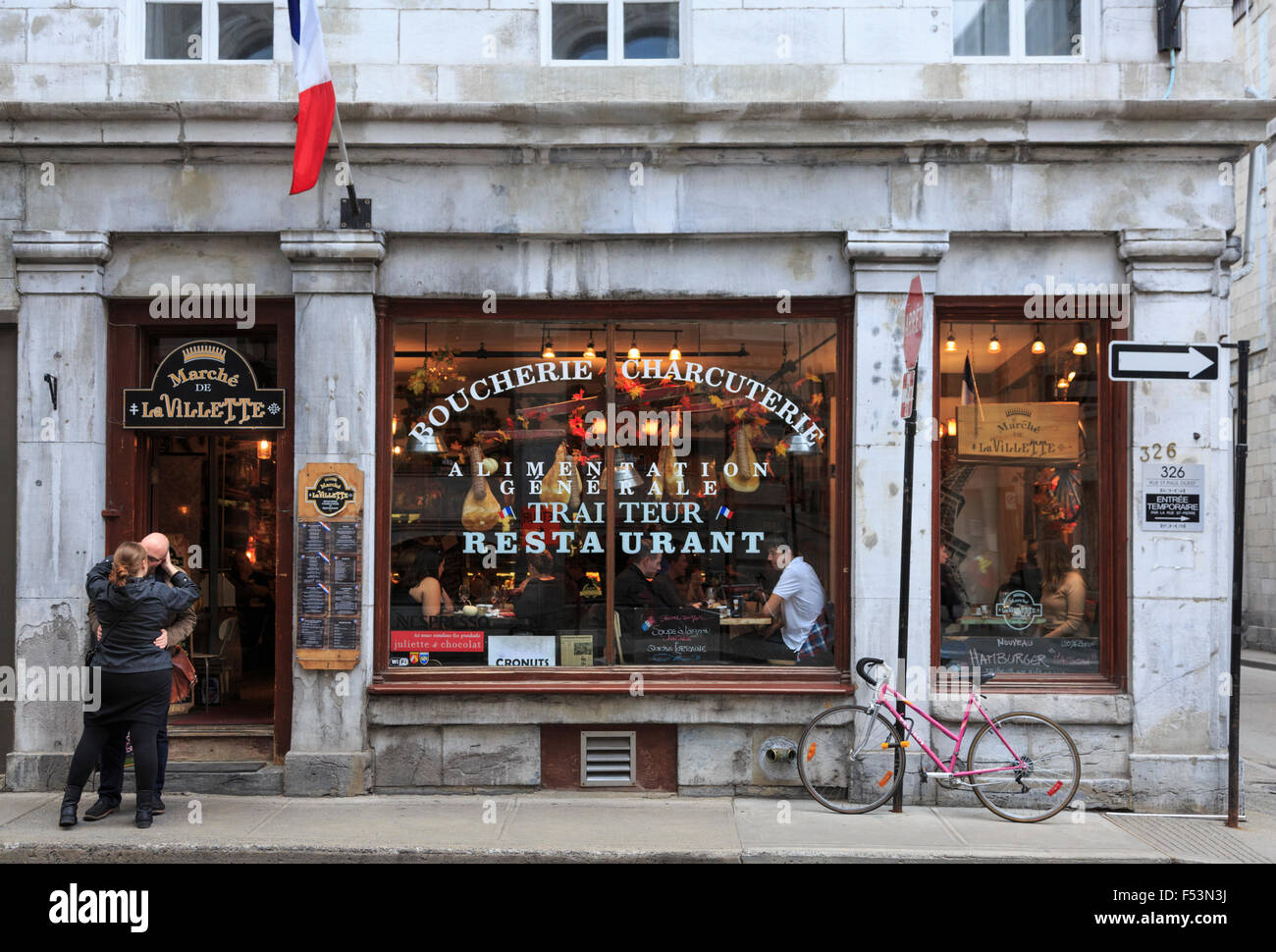 Couple kissing in front of restaurant in Old Montreal, Quebec, Canada Stock Photo