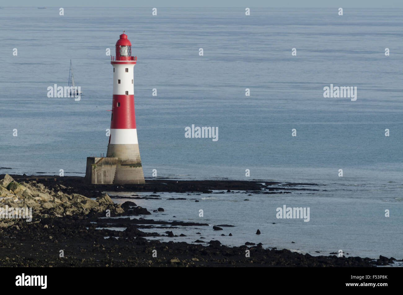 Red and White lighthouse at base of cliffs,  Beachy Head at low tide Stock Photo