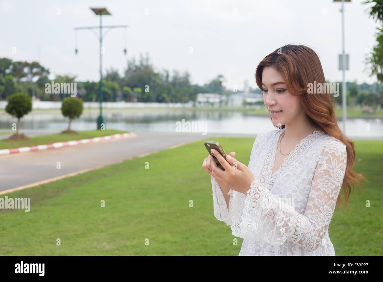 women sharing social media in a smart phone at public park Stock Photo