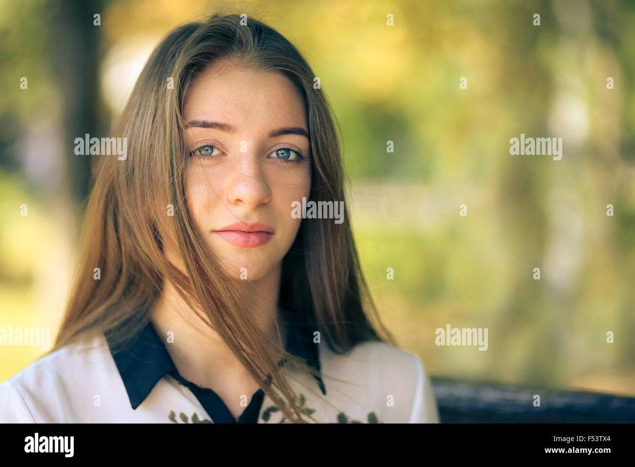 Young smiling teenage girl looking into camera. Pretty student girl enjoying summer day Stock Photo