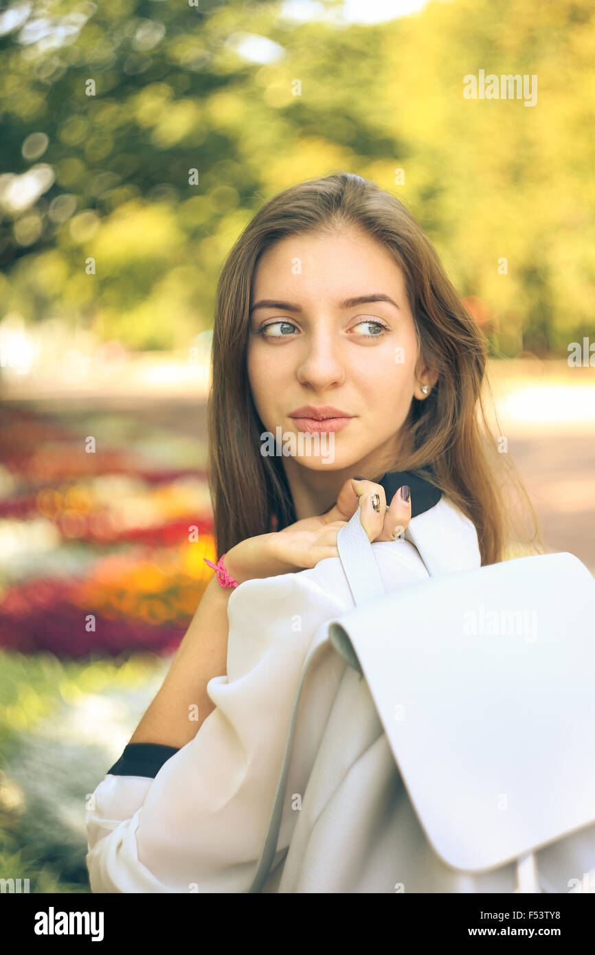 Pretty student girl with bag glanced over her shoulder in the autumn ...