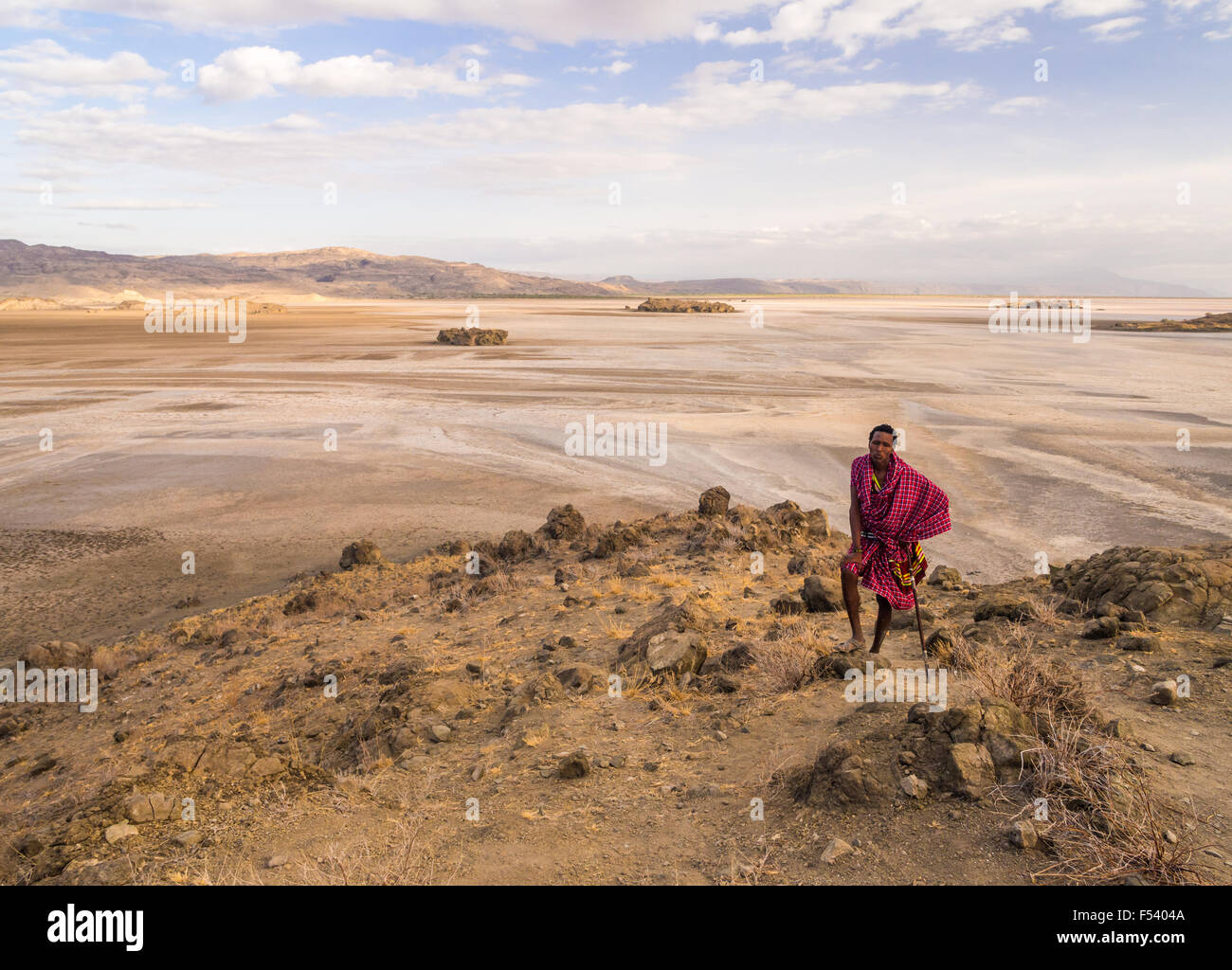 Maasai warrior wearing traditional red clothes in the dried part of Lake Natron in the North of Tanzania, Africa. Stock Photo