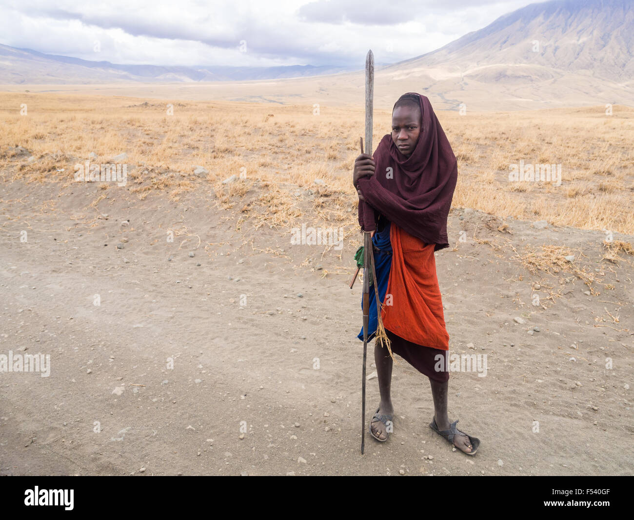 Young Maasai warriors on the road to Lake Natron. Ol Doinyo Lengai (Mountain of God in the Maasai language) in the background. Stock Photo