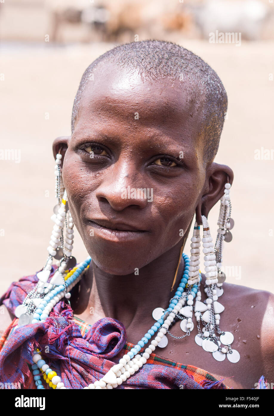 Maasai woman in Arusha region, Tanzania, Africa, selling souvenirs - mainly handmade jewelry - to foreign visitors. Stock Photo