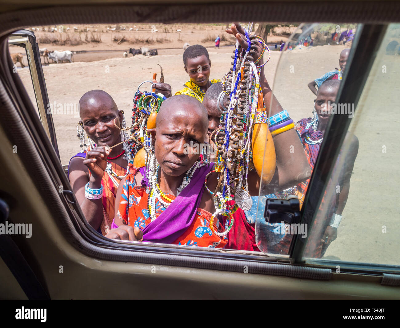 Maasai women offering souvenirs to the tourists through a car window in Arusha region, Tanzania, Africa. Stock Photo