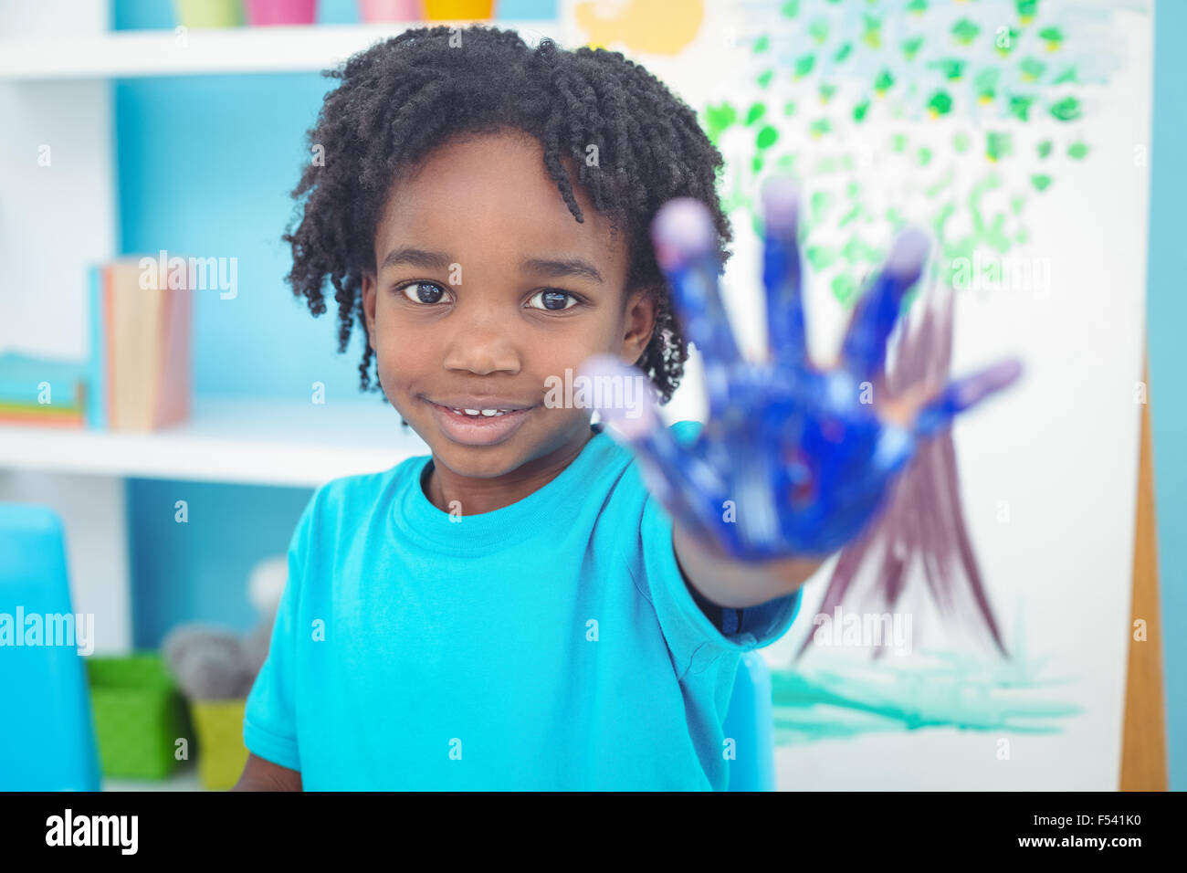 Happy kid enjoying painting with his hands Stock Photo