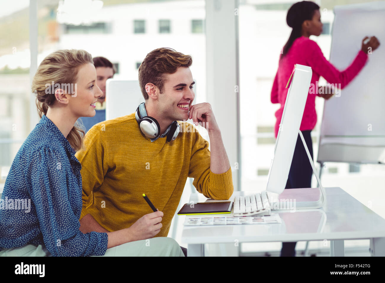 Graphic designer wearing headphones at desk Stock Photo Alamy