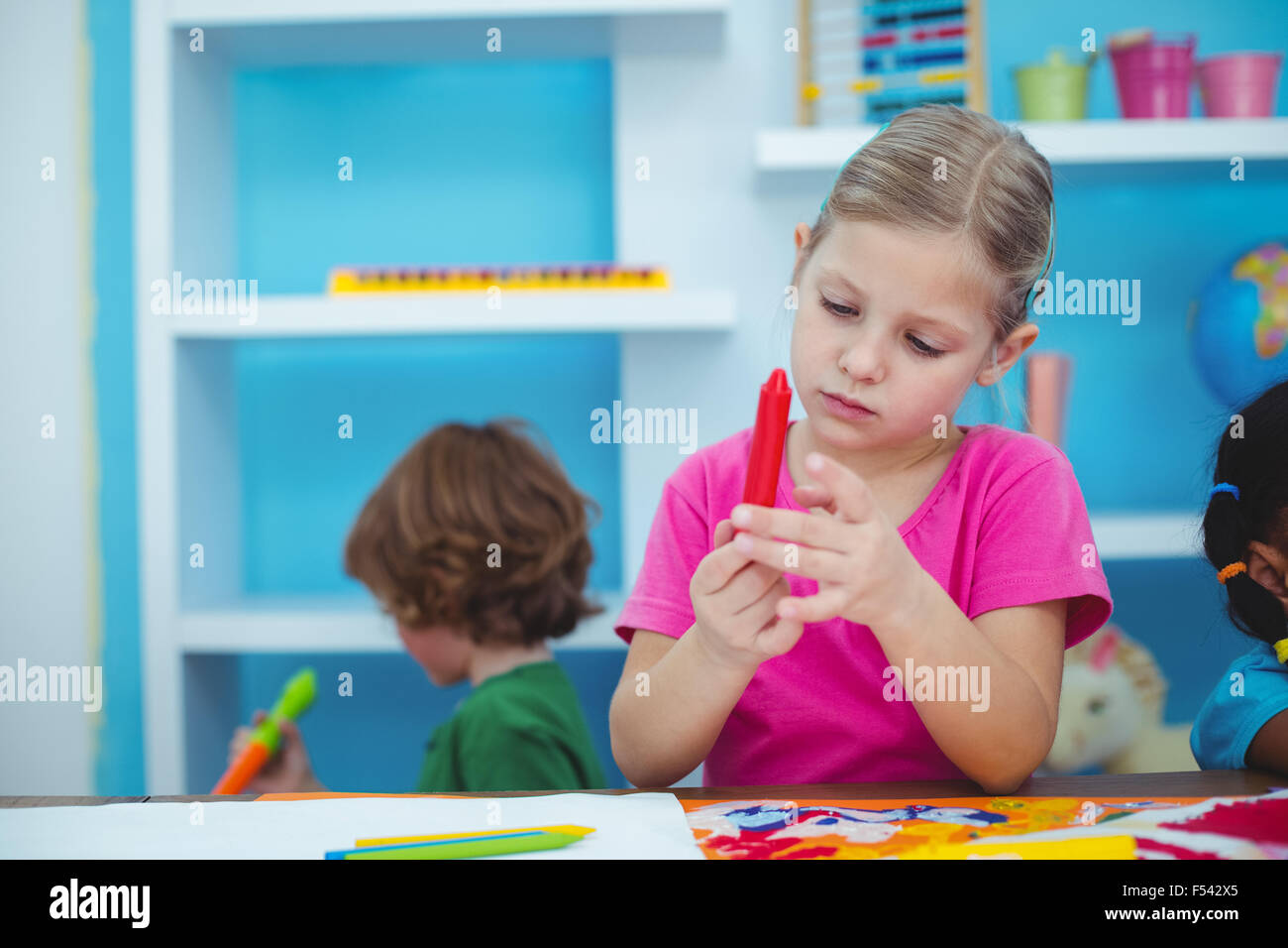 Small girl holding a red crayon Stock Photo