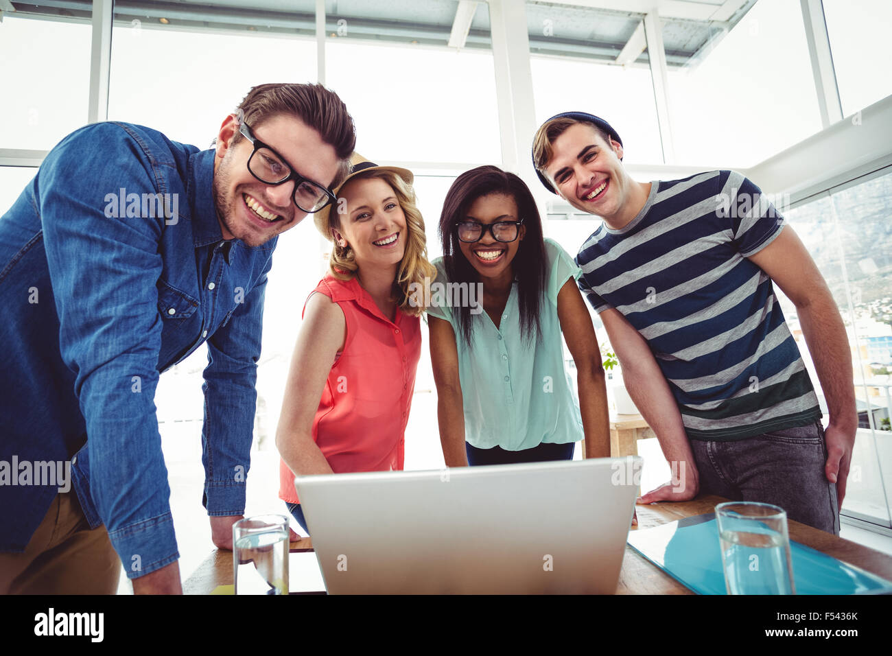 Creative business team working hard together on laptop Stock Photo - Alamy