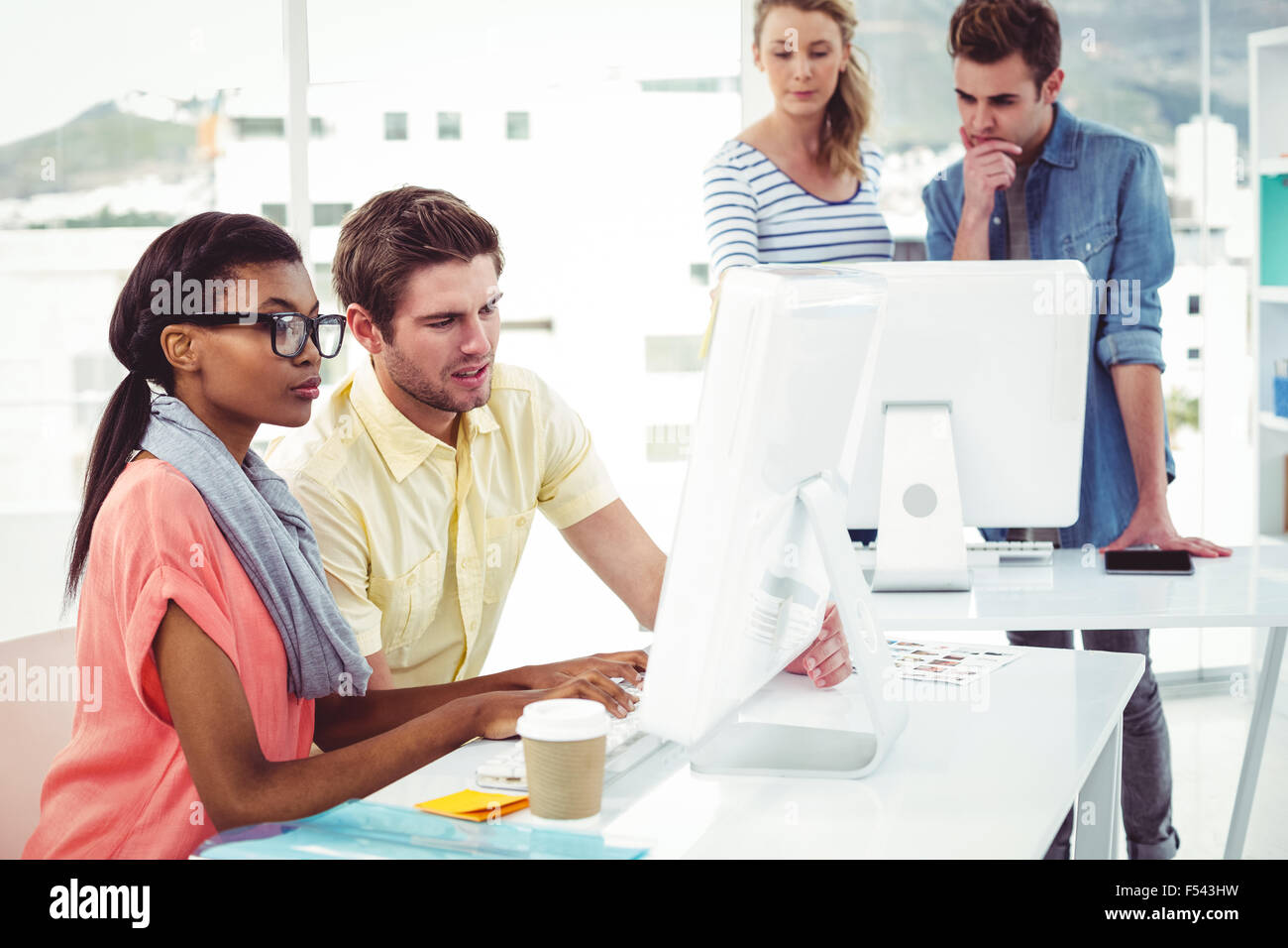 Creative business team working hard together on pc Stock Photo - Alamy