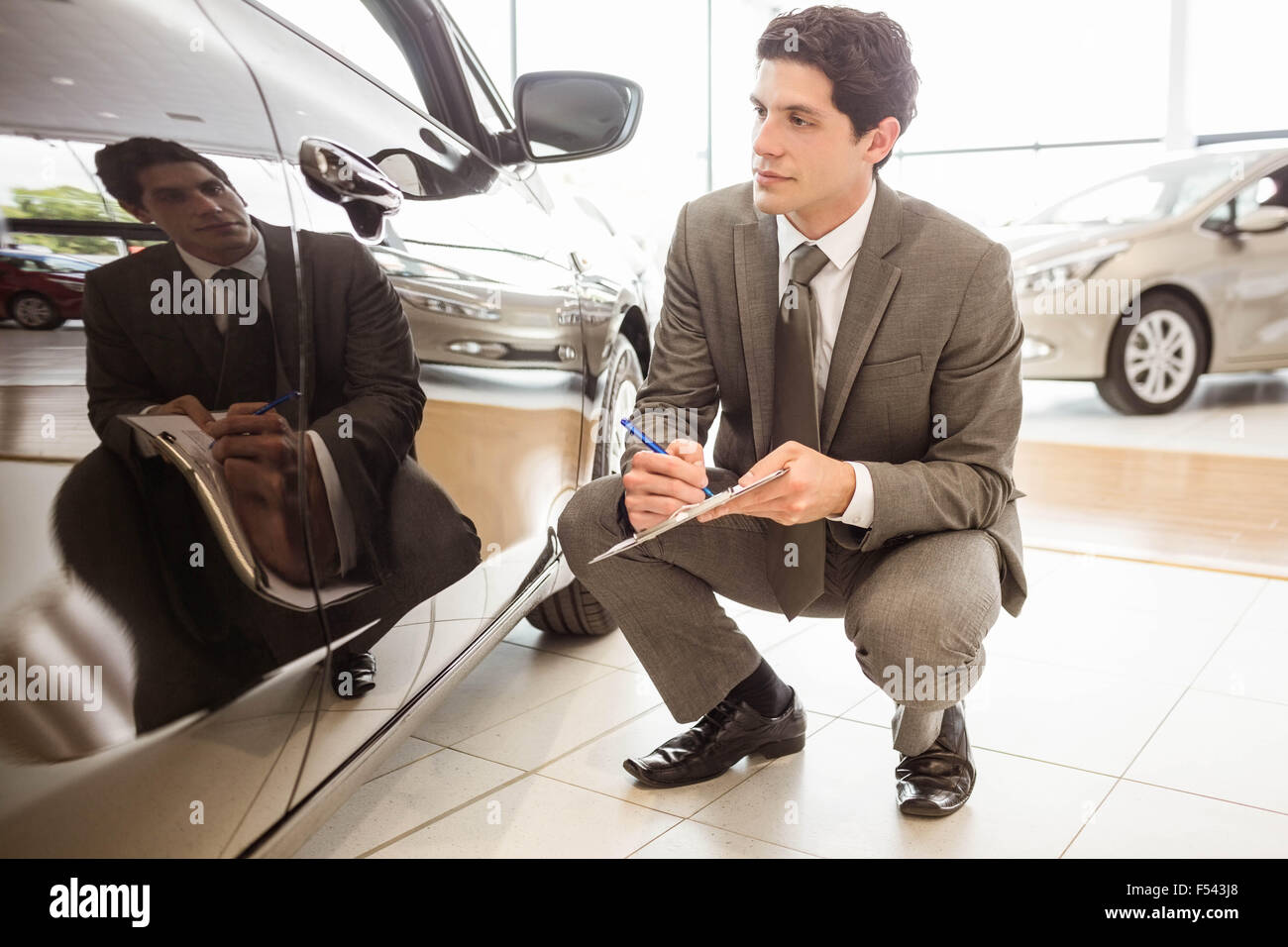 Focused businessman looking at the car body Stock Photo