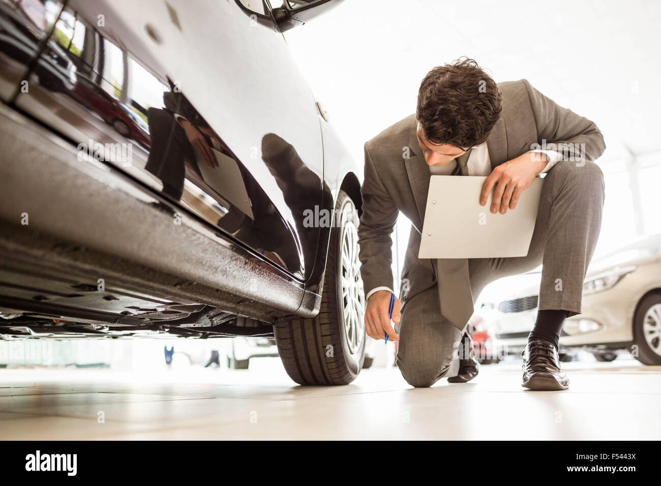 Focused businessman looking at the car body Stock Photo