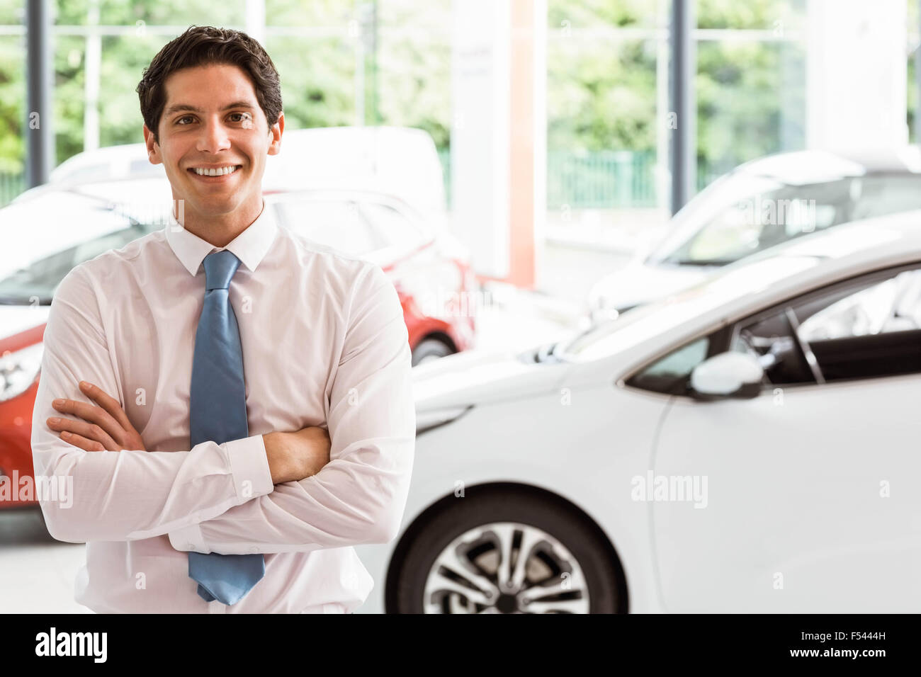 Smiling businessman standing with arms crossed Stock Photo - Alamy