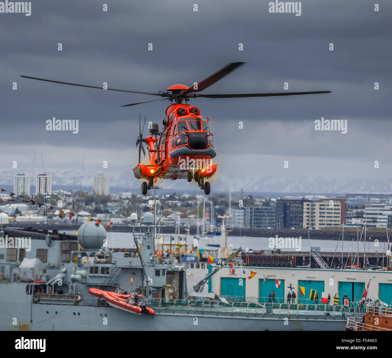 Search and Rescue Helicopter doing drills over Reykjavik, Harbor during the annual Seaman Day Festival. Stock Photo