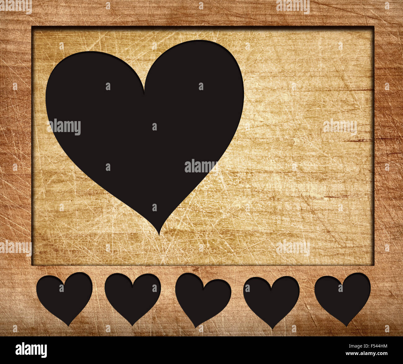 Hearts shape cut on wooden board with frame Stock Photo