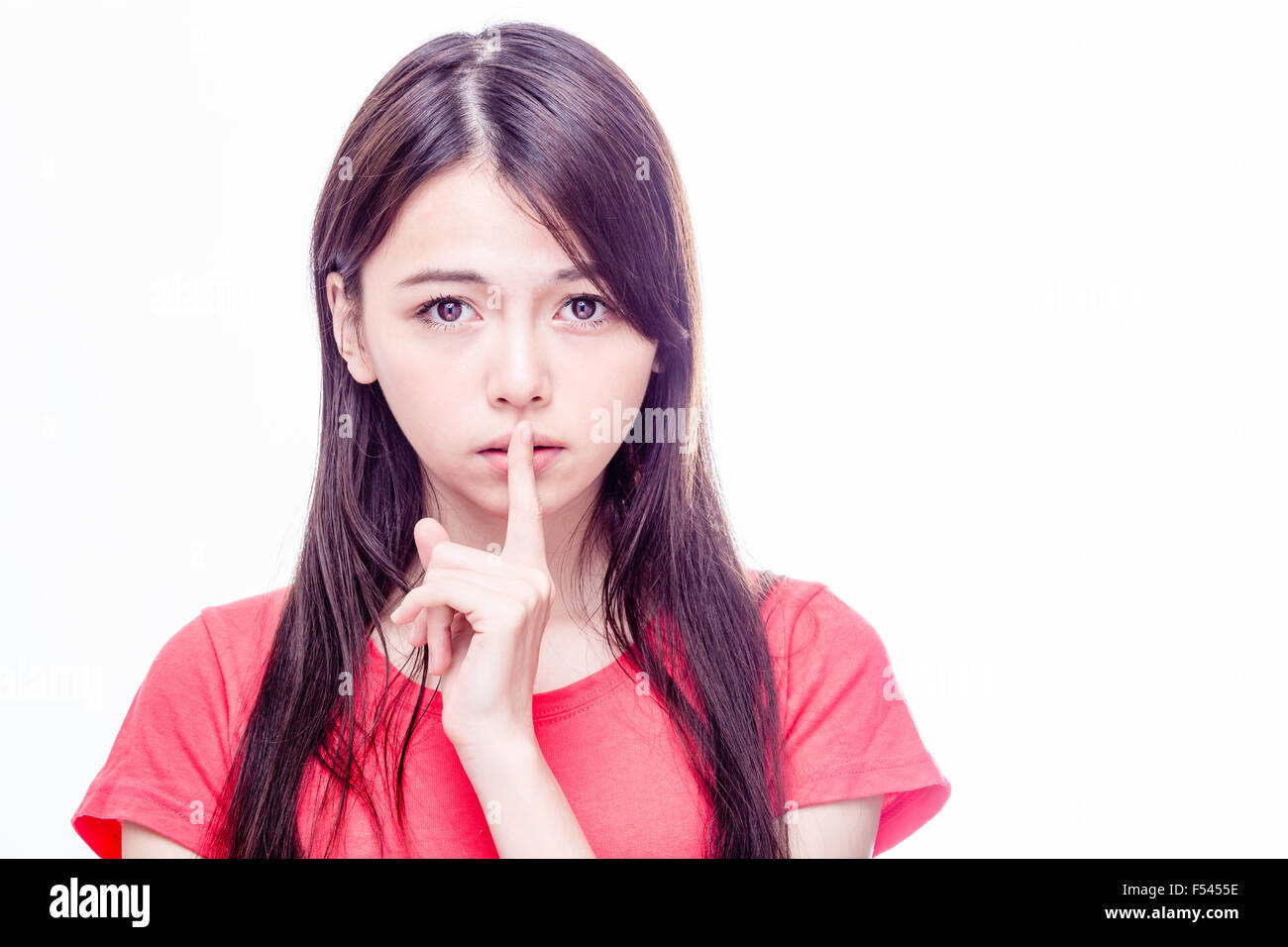 Chinese woman with finger on lips gesturing hush Stock Photo