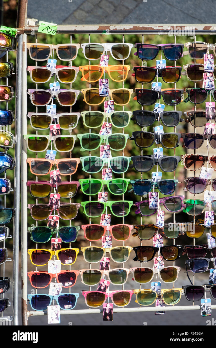 Lots of new pairs sunglasses with coloured frames for sale on a rack in a street market stall. Europe Stock Photo