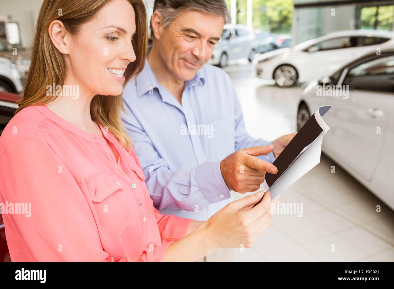 Smiling couple choosing the color of their new car Stock Photo