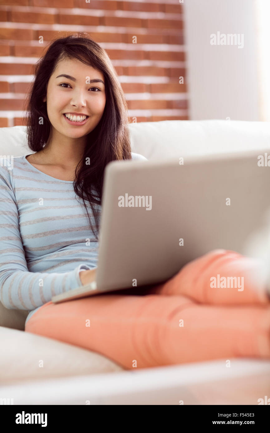 Asian woman on the couch using laptop Stock Photo - Alamy