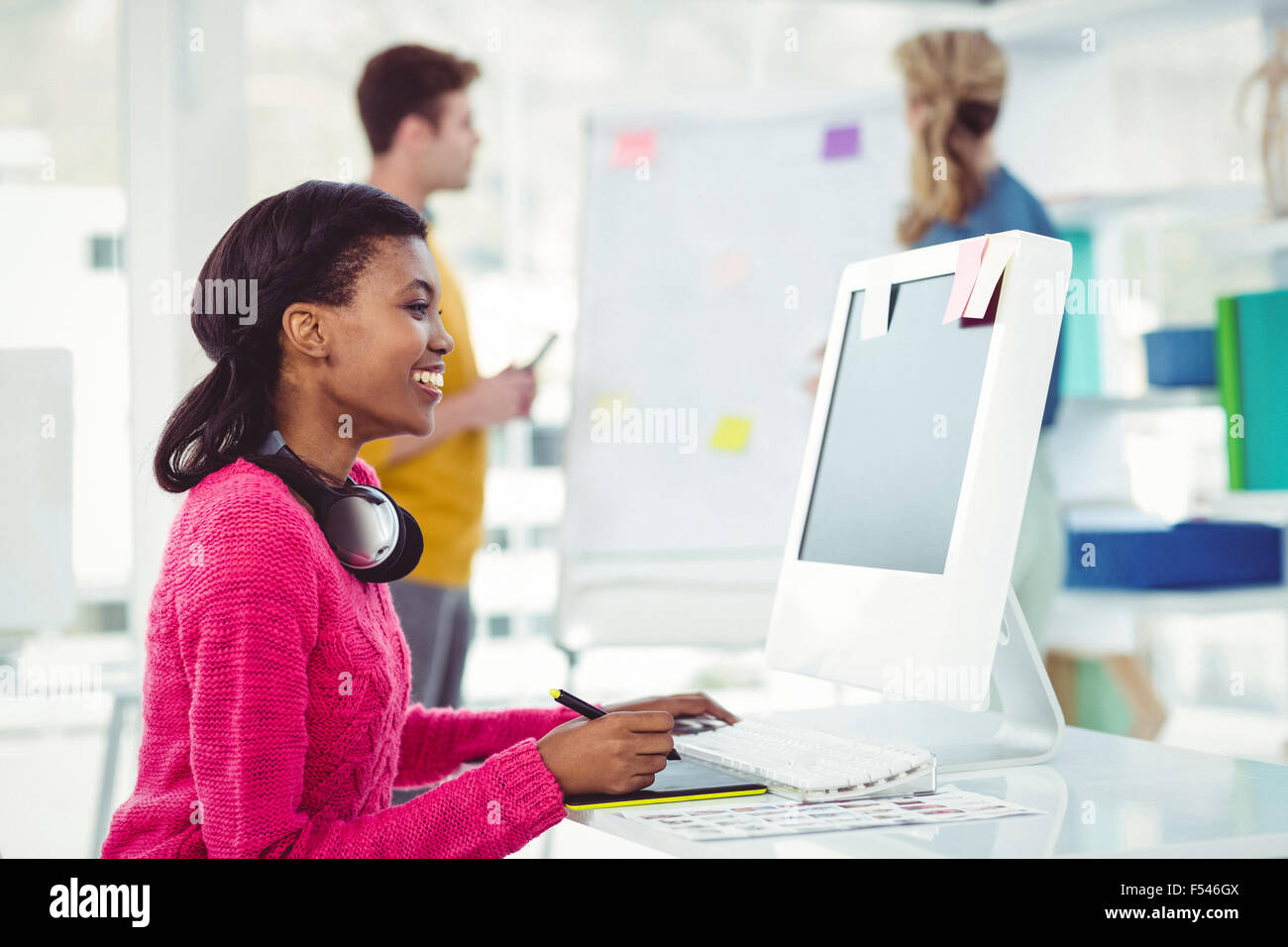Creative businesswoman wearing headphones at her desk Stock Photo - Alamy