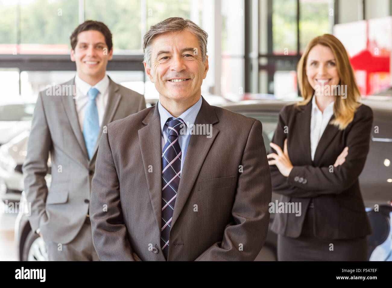 Group of smiling business team standing together Stock Photo - Alamy