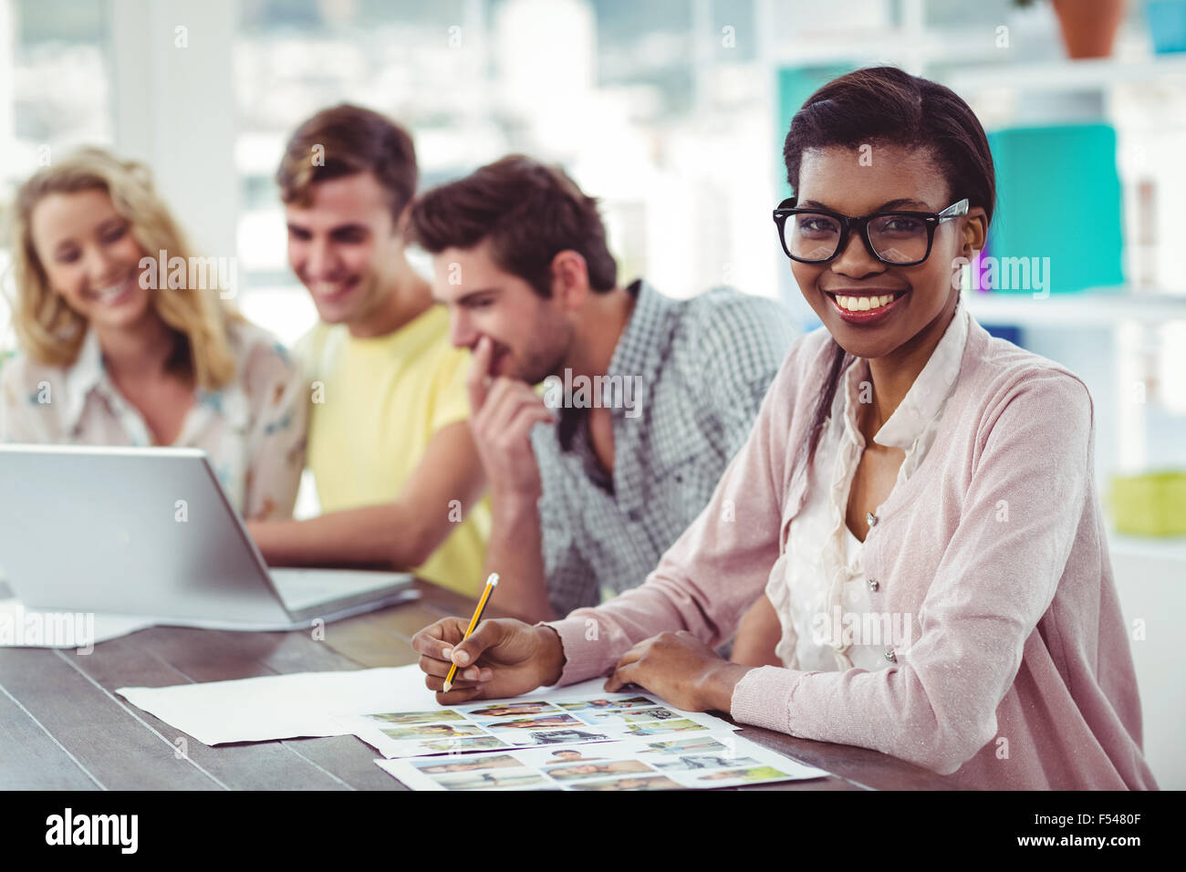 Creative business team working on a laptop together Stock Photo - Alamy