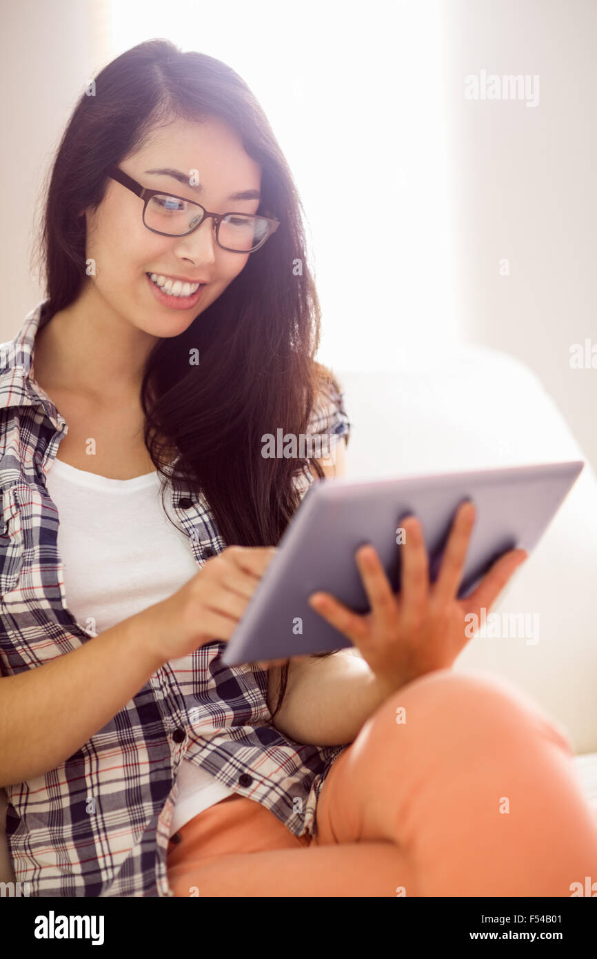 Asian woman on the couch using tablet Stock Photo - Alamy