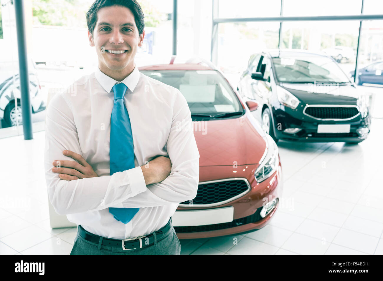 Smiling businessman standing with arms crossed Stock Photo - Alamy