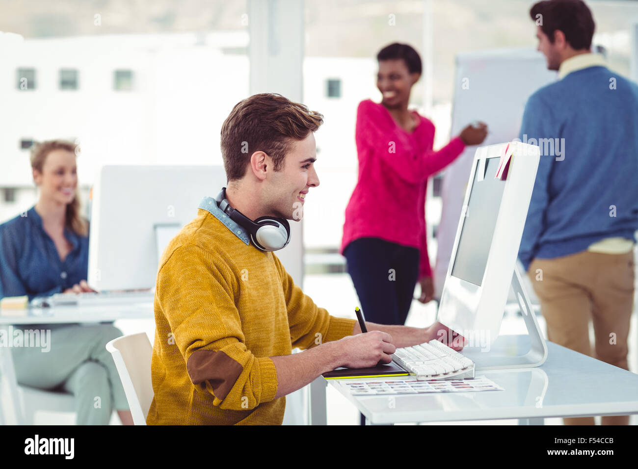 Graphic designer wearing headphones at desk Stock Photo Alamy
