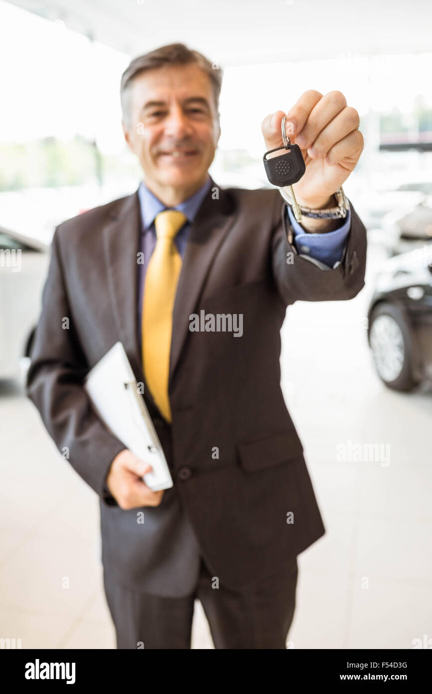 Male driver showing a key after buying a new car Stock Photo