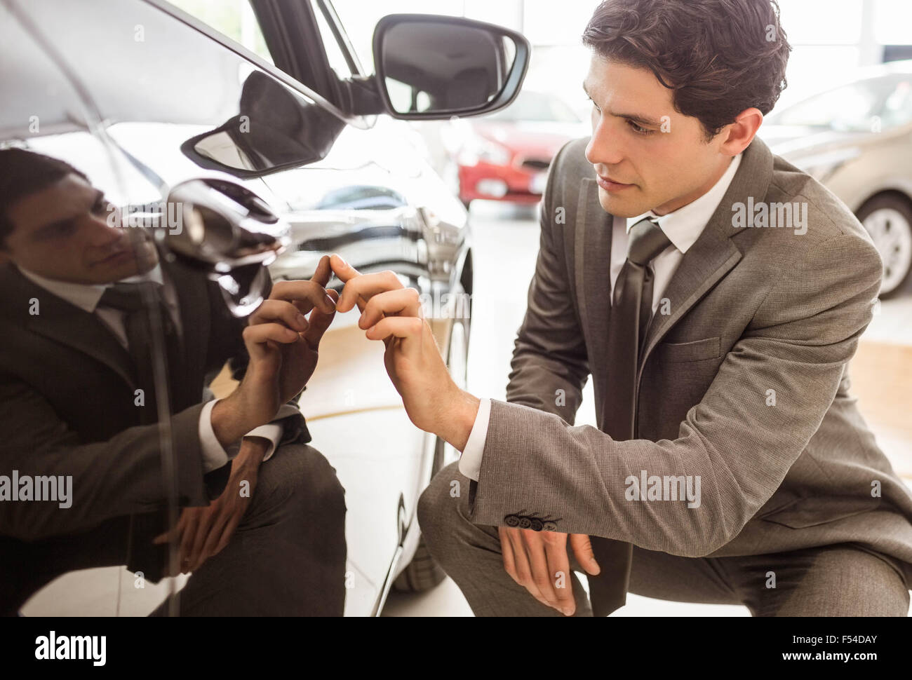 Focused businessman looking at the car body Stock Photo