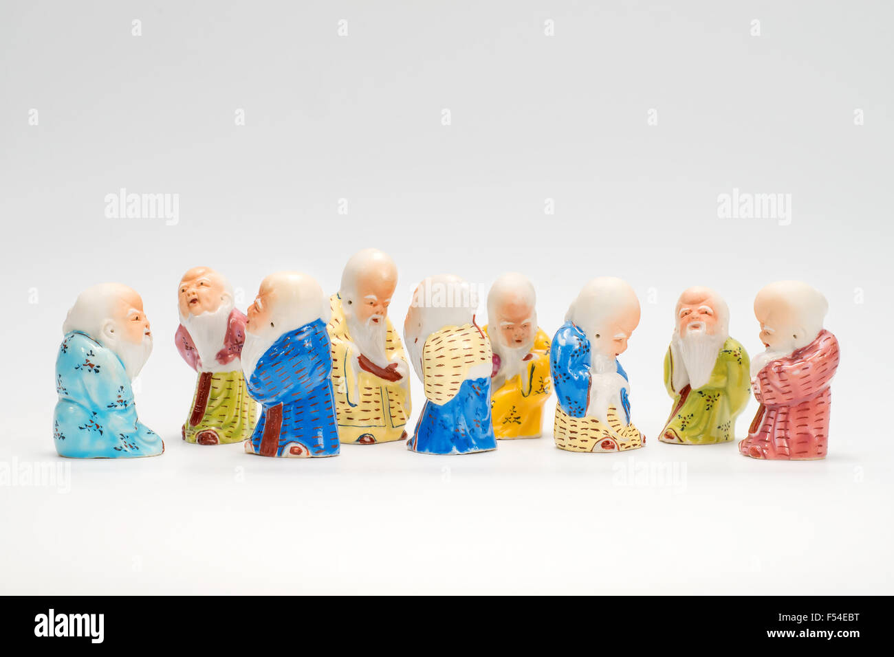 Scene with nine ancient  porcelain figurines of the Chinese sages on white background Stock Photo