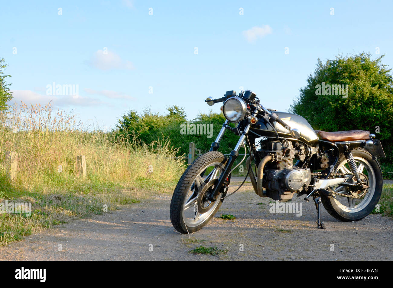 Honda Cafe Racer motorbike in black photographed infront of a field of  grass Stock Photo - Alamy