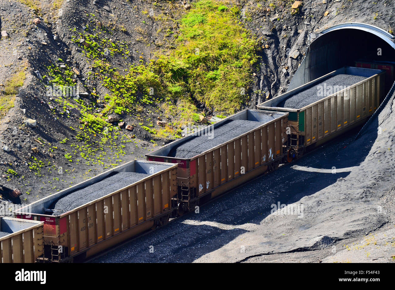 A close up horizontal image of railway cars loaded with coal oar traveling through a tunnel Stock Photo
