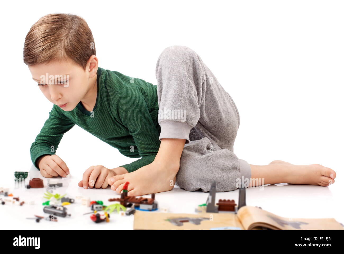 Handsome guy who is playing and building something from book Stock Photo