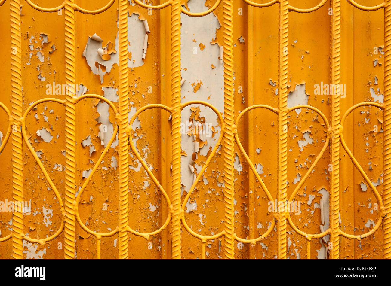 Rod metal yellow fence surface abstract, decorative old fence with hearts like shaped wires and weathered orange color paint ... Stock Photo